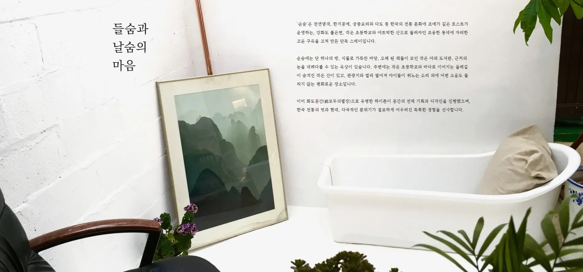 공간 순숨 액자가 걸린 흰 벽과 욕조
